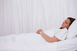 Woman resting in bed, illustrating fatigue and neurological health concerns