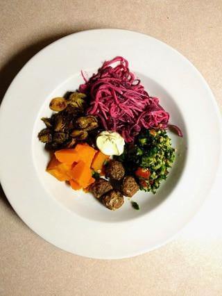 Healthy paleo meal with roasted vegetables, purple cabbage slaw, meatballs, and greens