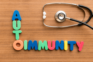 Autoimmunity text with colorful letters and stethoscope on wooden background