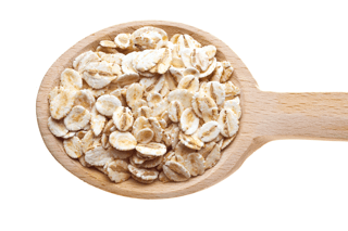 Wooden spoon filled with raw whole grain oats on a white background