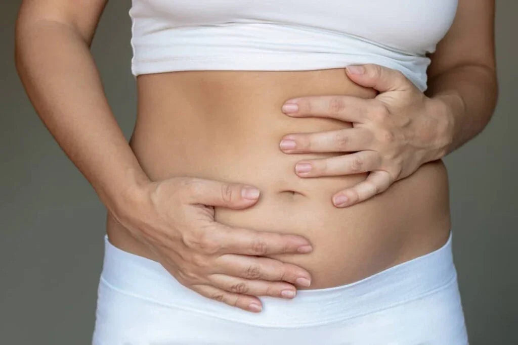 Woman holding bloated stomach, gut health and digestive wellness concept